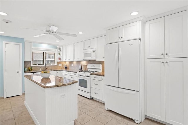 kitchen featuring stone countertops, white cabinetry, white appliances, and light tile patterned floors