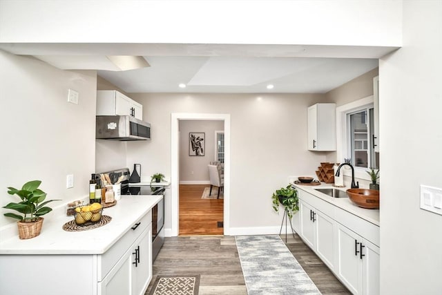 kitchen featuring sink, white cabinets, stainless steel appliances, and wood-type flooring