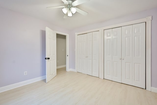 unfurnished bedroom with ceiling fan, multiple closets, and light hardwood / wood-style flooring