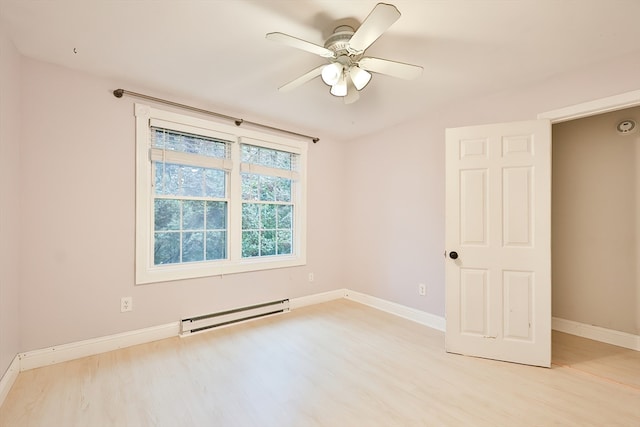 spare room with a baseboard heating unit, ceiling fan, and light wood-type flooring