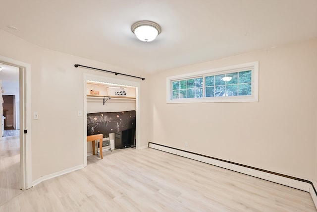 unfurnished bedroom with light hardwood / wood-style floors, baseboard heating, and a closet