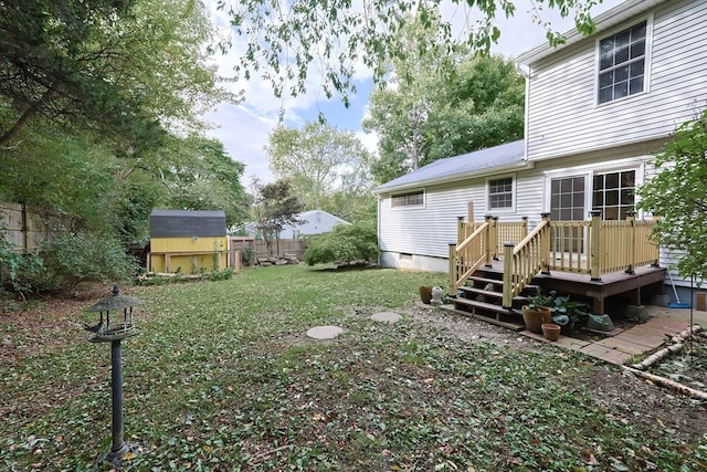 view of yard featuring a wooden deck and a storage unit