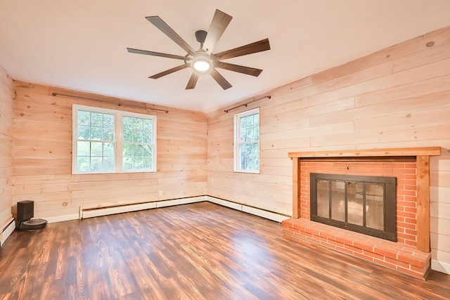 unfurnished living room with wooden walls, ceiling fan, hardwood / wood-style flooring, and a fireplace