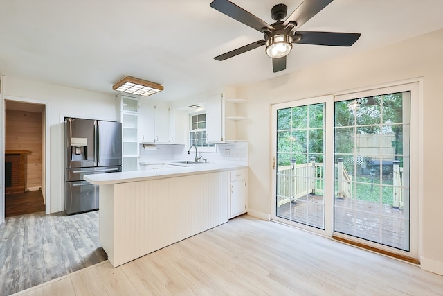 kitchen featuring decorative backsplash, white cabinetry, kitchen peninsula, ceiling fan, and stainless steel fridge with ice dispenser