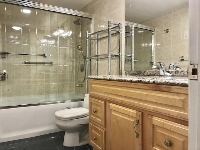 full bathroom featuring toilet, tile patterned floors, vanity, and enclosed tub / shower combo