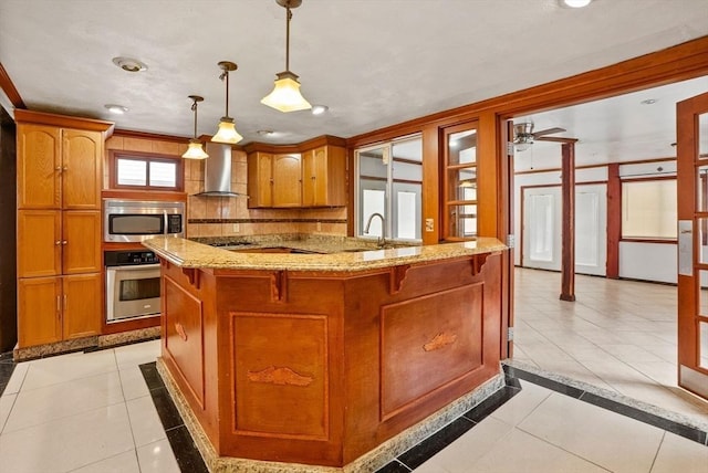 kitchen featuring wall chimney range hood, light tile patterned floors, brown cabinets, and stainless steel appliances