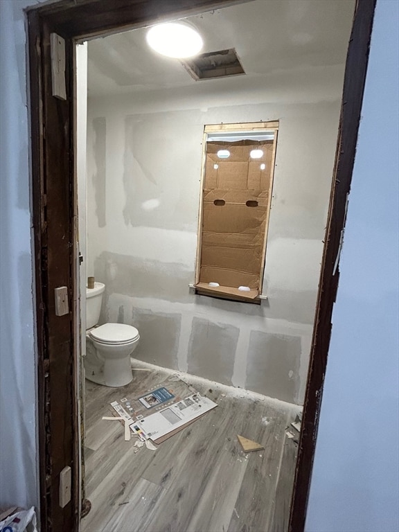 bathroom with toilet and hardwood / wood-style flooring