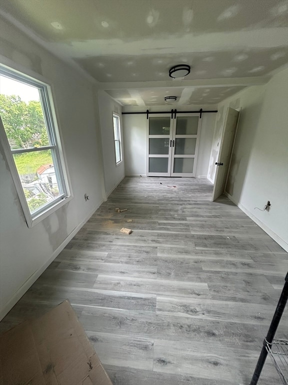 spare room with a barn door and light wood-type flooring