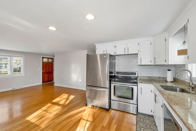 kitchen with decorative backsplash, appliances with stainless steel finishes, light stone counters, sink, and white cabinets