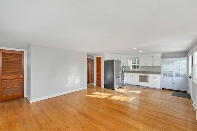 unfurnished living room with light hardwood / wood-style floors and sink