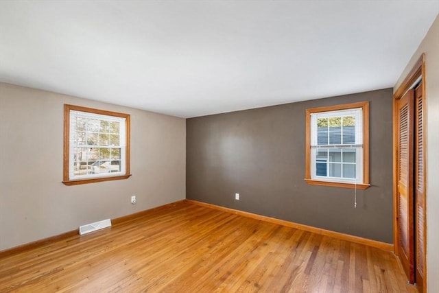 unfurnished bedroom with a closet and light hardwood / wood-style flooring