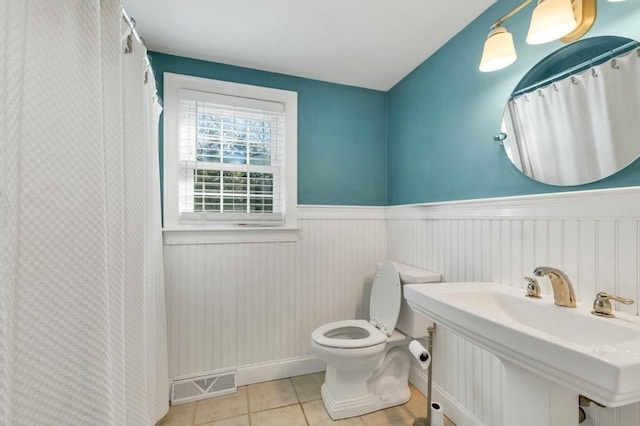 bathroom featuring tile patterned flooring, toilet, and sink