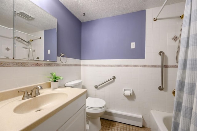 11 Williamsburg Ln, Scituate, MA 02066 - bathroom with a baseboard radiator, a textured ceiling, tile walls, vanity, and wainscoting