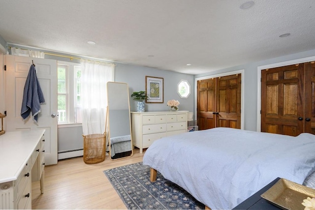 11 Williamsburg Ln, Scituate, MA 02066 - bedroom featuring a baseboard heating unit, light wood-style floors, and recessed lighting