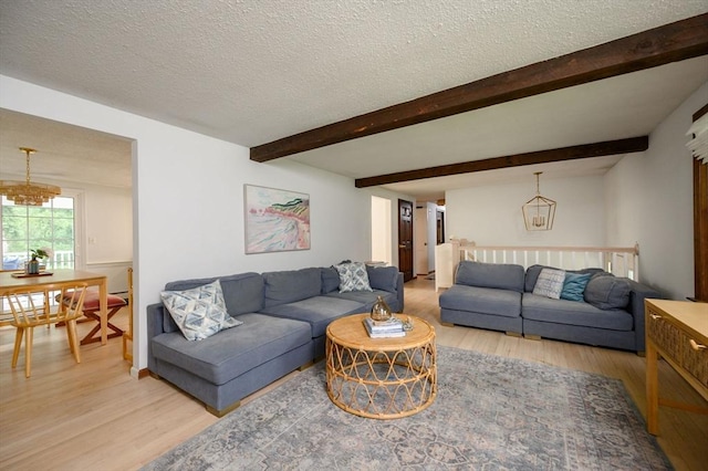 11 Williamsburg Ln, Scituate, MA 02066 - living room with light wood-style flooring, a chandelier, a textured ceiling, and beamed ceiling
