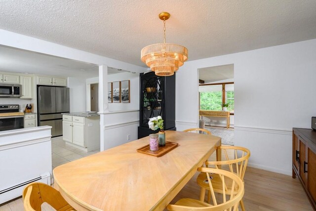 11 Williamsburg Ln, Scituate, MA 02066 - dining area with baseboard heating, a chandelier, and a textured ceiling
