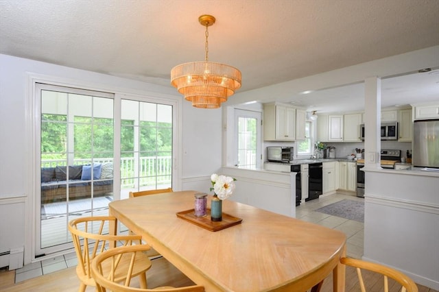 11 Williamsburg Ln, Scituate, MA 02066 - dining room with light tile patterned floors, a chandelier, a textured ceiling, and a baseboard heating unit