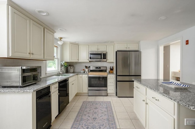 11 Williamsburg Ln, Scituate, MA 02066 - kitchen with stainless steel appliances, backsplash, cream cabinets, light stone countertops, and light tile patterned flooring