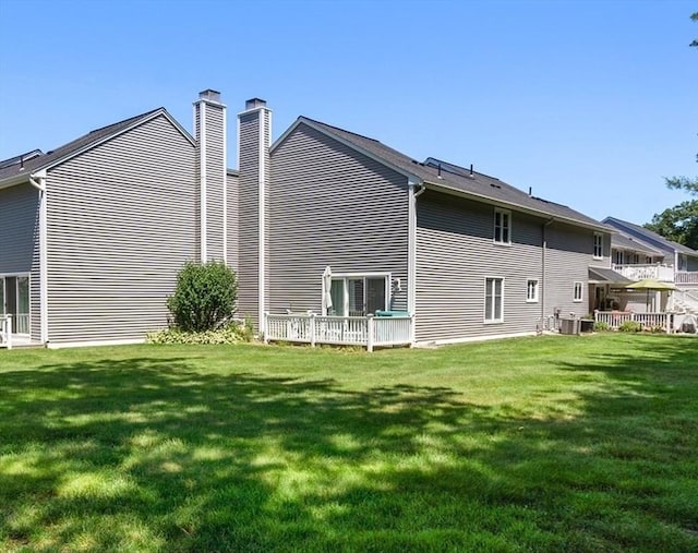 84 Chapin Greene Unit 84, Ludlow, MA 01056 - rear view of property featuring a chimney and a lawn