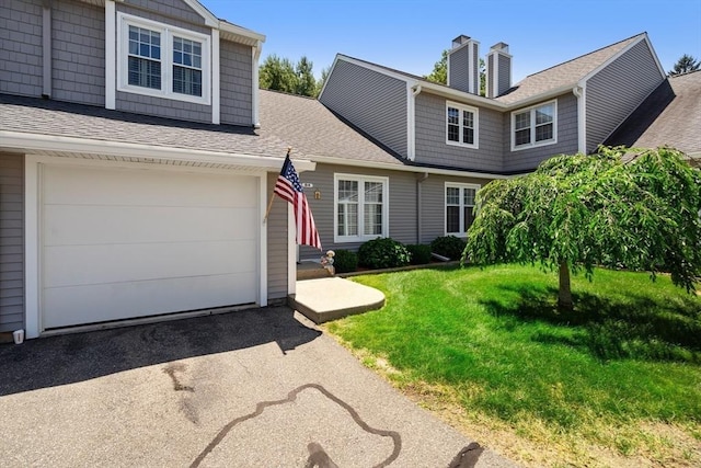 84 Chapin Greene Unit 84, Ludlow, MA 01056 - view of front facade with driveway, a chimney, a front lawn, and a shingled roof