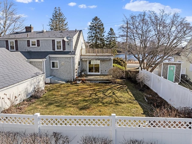 back of house with a lawn and a fenced backyard