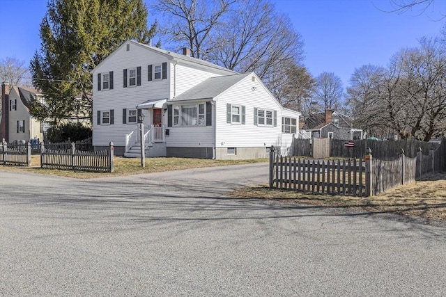 view of front of property with a fenced front yard and a chimney