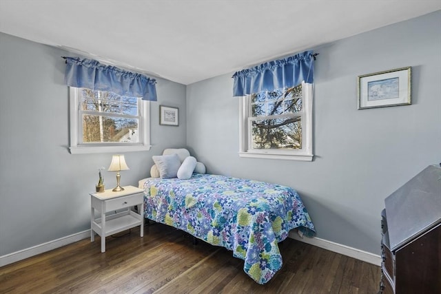 bedroom featuring multiple windows, baseboards, and wood finished floors