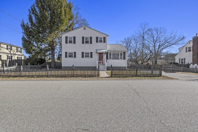 traditional-style home featuring entry steps and a fenced front yard