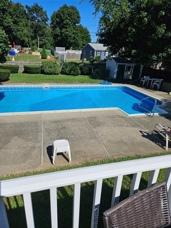 view of swimming pool with a fenced in pool, a patio, an outdoor structure, and fence