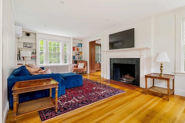 96 Nonantum St, Newton, MA 02458 - living area with radiator, built in shelves, hardwood / wood-style floors, a fireplace, and ornamental molding
