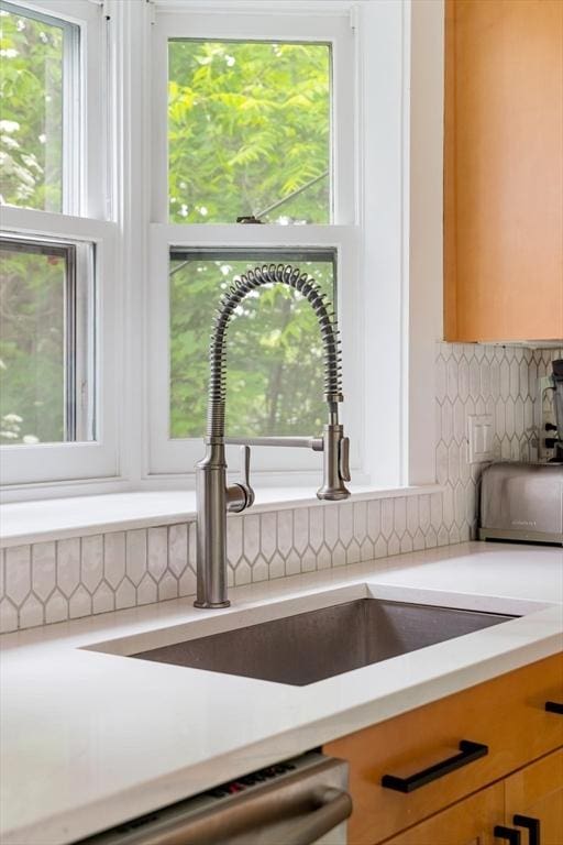 96 Nonantum St, Newton, MA 02458 - kitchen view of light countertops, a sink, decorative backsplash, and stainless steel dishwasher