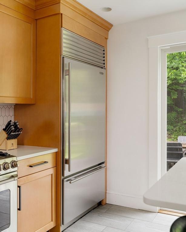 96 Nonantum St, Newton, MA 02458 - kitchen with stainless steel appliances, light countertops, backsplash, and baseboards