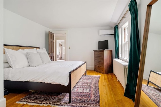 96 Nonantum St, Newton, MA 02458 - bedroom with a wall unit AC, radiator, light wood-style flooring, and lofted ceiling