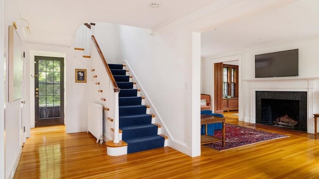 96 Nonantum St, Newton, MA 02458 - staircase featuring wood finished floors, a brick fireplace, baseboards, and radiator heating unit