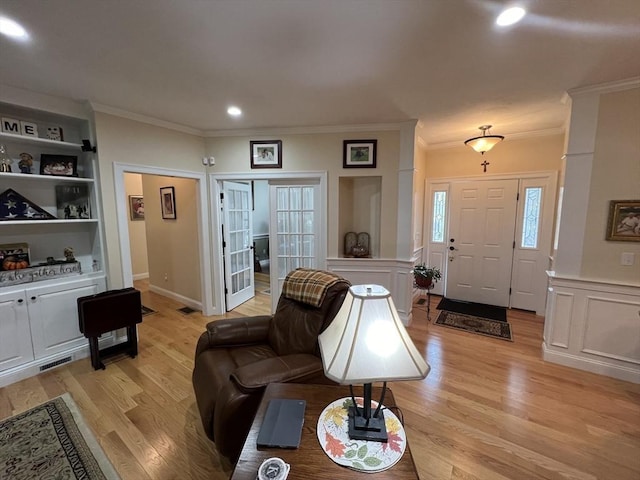 living room featuring ornamental molding and light wood-type flooring