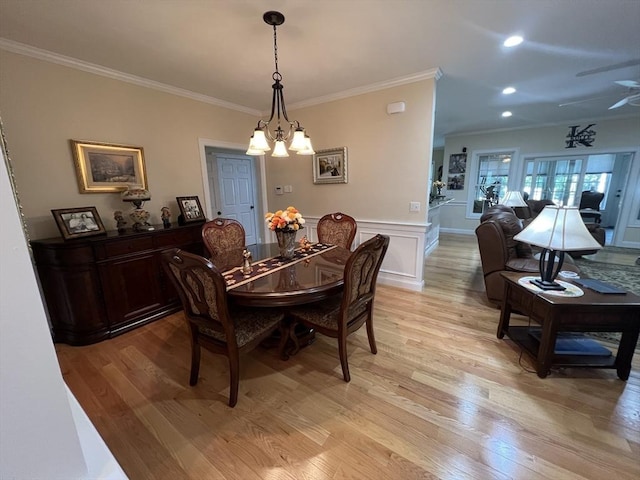 dining area with an inviting chandelier, ornamental molding, and light hardwood / wood-style floors