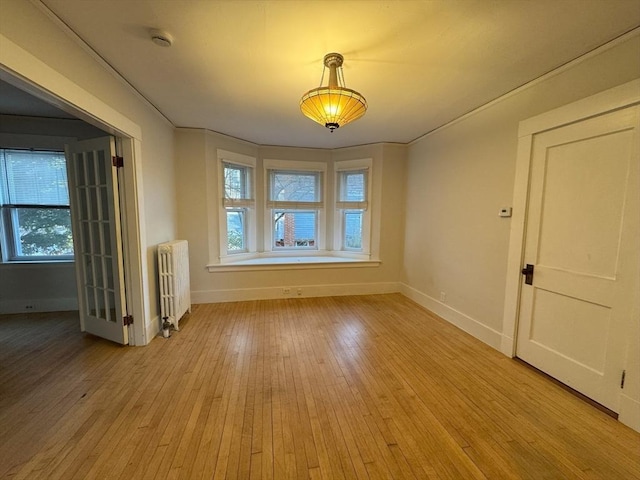 unfurnished room with light wood-type flooring and radiator