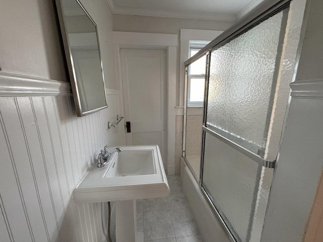 bathroom with tile patterned floors, ornamental molding, and combined bath / shower with glass door