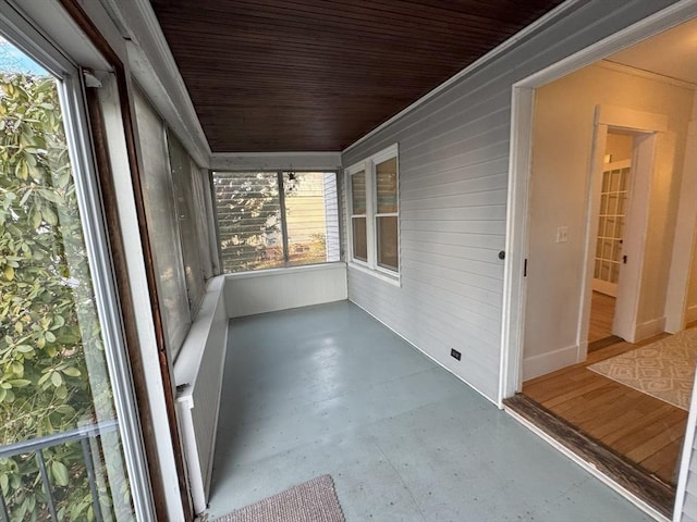 unfurnished sunroom featuring wood ceiling and a wealth of natural light