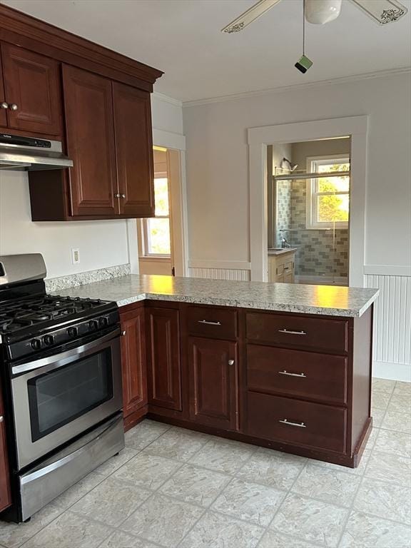 kitchen with kitchen peninsula, gas stove, crown molding, and a healthy amount of sunlight