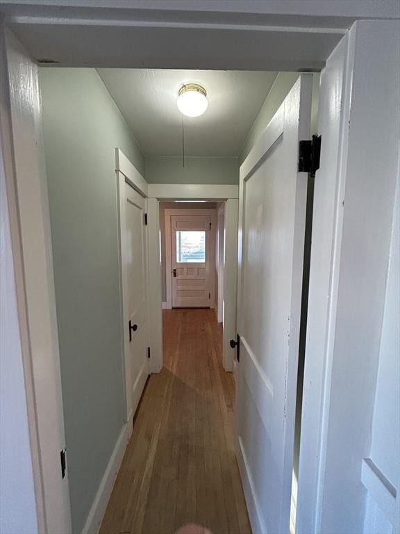 hallway with hardwood / wood-style flooring