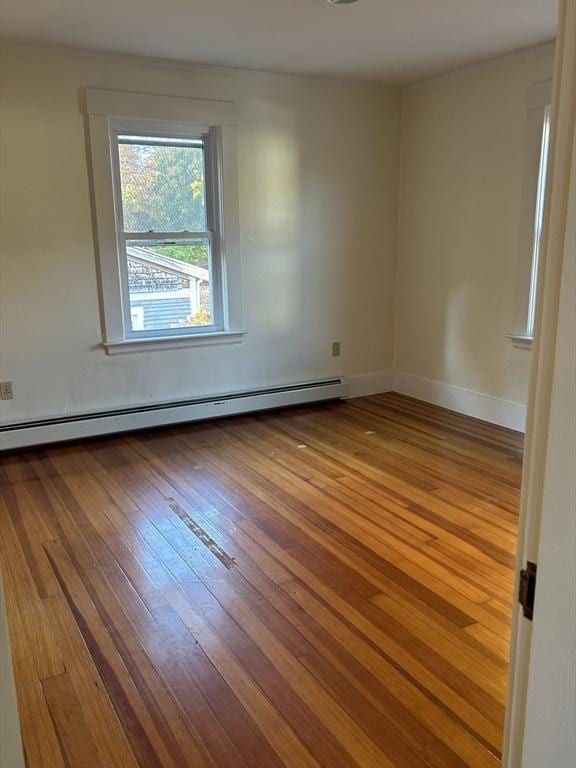 unfurnished room with light hardwood / wood-style flooring and a baseboard heating unit