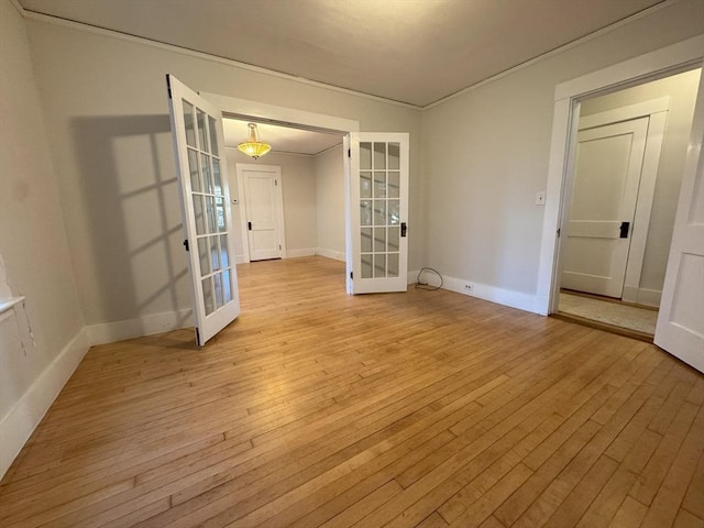 empty room with light hardwood / wood-style flooring and french doors