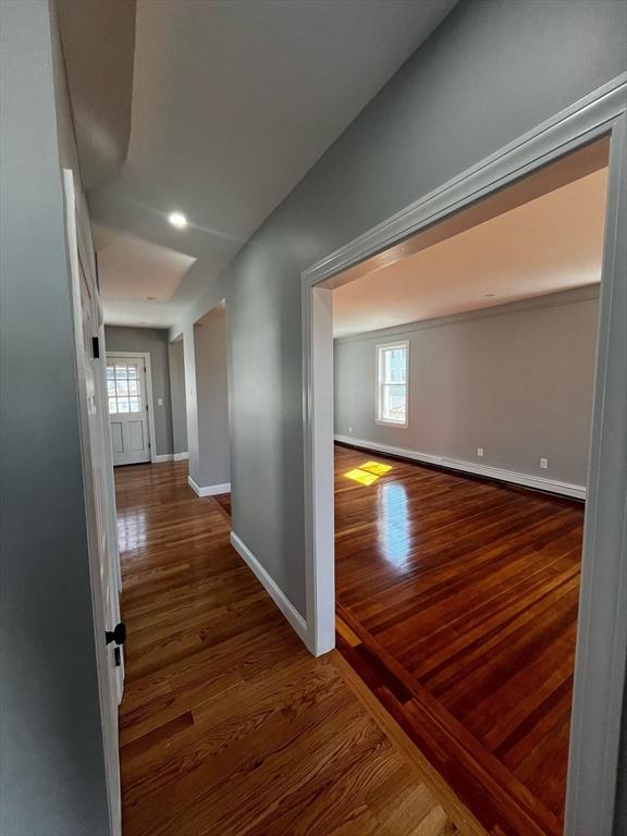 hallway with baseboards and wood finished floors