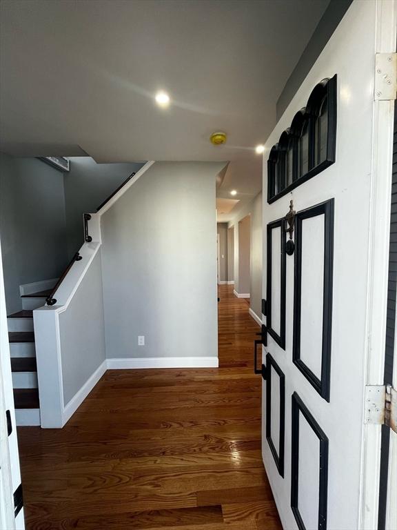 hall featuring recessed lighting, wood finished floors, and baseboards
