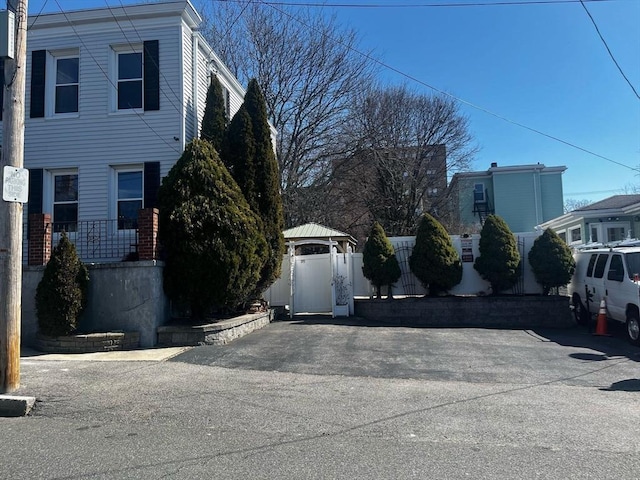 view of property exterior with fence and a gate