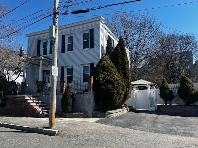view of front of home with fence, covered porch, and a gate