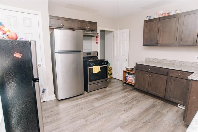 kitchen with under cabinet range hood, dark brown cabinetry, appliances with stainless steel finishes, and light wood-type flooring