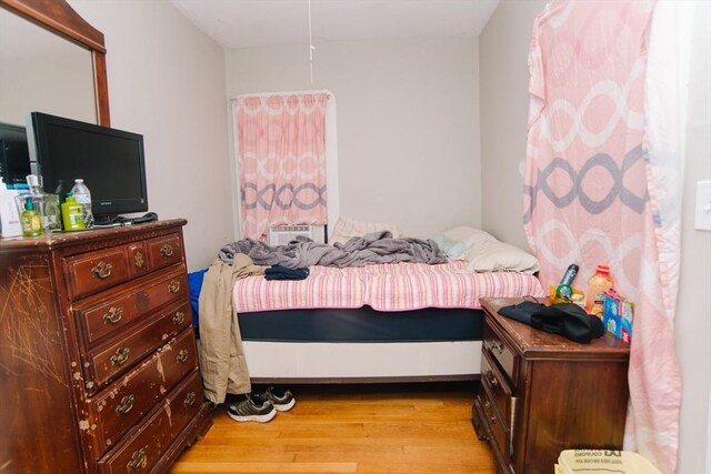 bedroom with light wood-style flooring and cooling unit