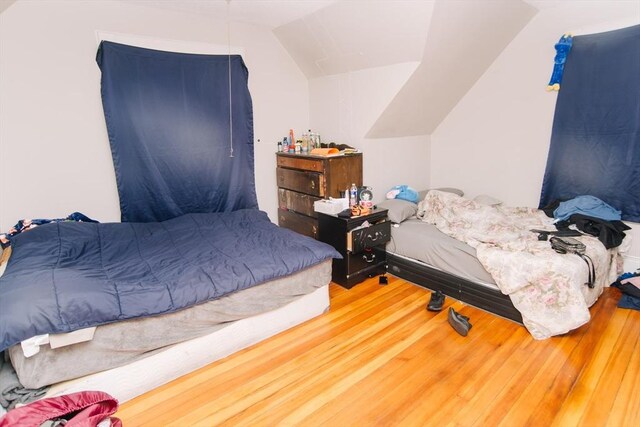 bedroom featuring lofted ceiling and wood finished floors